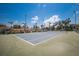 Tennis court with trees and blue skies in the background at 7100 Gulf Dr # 114, Holmes Beach, FL 34217
