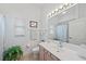Well-lit bathroom with a large mirror, white countertops, and a large green plant at 750 Anna Hope Ln, Osprey, FL 34229