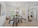 Elegant dining room featuring a glass table, striped chairs, chandelier, and natural light from the large window at 750 Anna Hope Ln, Osprey, FL 34229