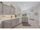 Bright kitchen featuring gray cabinets, white appliances, and a large window offering backyard views at 750 Anna Hope Ln, Osprey, FL 34229
