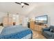 Bright bedroom featuring a comfortable blue bed, dresser, TV and wood flooring at 7907 4Th W Ave # 7907, Bradenton, FL 34209
