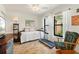 Bright bedroom features wood-look tile flooring, daybed, and treadmill for exercise and relaxation at 7907 4Th W Ave # 7907, Bradenton, FL 34209