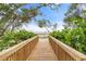 Scenic wooden walkway leads to water views from the deck, surrounded by lush greenery at 7907 4Th W Ave # 7907, Bradenton, FL 34209