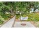 Private property entrance with lush greenery leading to Pine Bay Forest at 7907 4Th W Ave # 7907, Bradenton, FL 34209