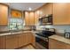 Well-lit kitchen with stainless steel appliances, granite countertops, and bright wood cabinets at 7907 4Th W Ave # 7907, Bradenton, FL 34209