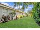 An expansive lawn runs along the back of the home, bordered by manicured shrubs and tropical plants at 104 Park Trace Blvd, Osprey, FL 34229