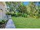 Spacious backyard with green grass, fence and mature trees in a peaceful setting at 104 Park Trace Blvd, Osprey, FL 34229