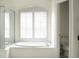 Bright bathroom with a large soaking tub under an arched window and a glass shower at 104 Park Trace Blvd, Osprey, FL 34229
