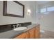 Bathroom featuring a dark granite vanity, bathtub and shower with white tile, and shuttered window at 104 Park Trace Blvd, Osprey, FL 34229
