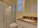 Bright bathroom featuring granite sink with brushed nickel faucet and a sliding glass shower enclosure at 104 Park Trace Blvd, Osprey, FL 34229