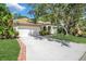 Beautiful home featuring a manicured lawn, mature trees, and a brick-lined driveway at 104 Park Trace Blvd, Osprey, FL 34229