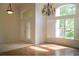 Bright and airy living room with hardwood floors, plantation shutters, and a decorative chandelier at 104 Park Trace Blvd, Osprey, FL 34229