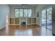 Spacious living room with hardwood floors, built-in shelves, and a view of the screened-in pool at 104 Park Trace Blvd, Osprey, FL 34229