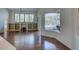 Open-concept living area with hardwood floors, built-in shelving, and a glimpse of the pool area at 104 Park Trace Blvd, Osprey, FL 34229