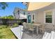 Backyard deck featuring an outdoor dining set, grassy backyard, and black fence at 1140 Oak Ne St, St Petersburg, FL 33701