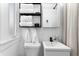 Bright bathroom with white fixtures, shower, and shelving unit with towels for storage at 1140 Oak Ne St, St Petersburg, FL 33701