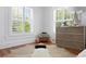 Sunlit bedroom with hardwood floors, white walls, plantation shutters, and a decorative wooden dresser at 1140 Oak Ne St, St Petersburg, FL 33701