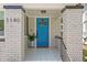Inviting entryway featuring a vibrant blue door, decorative tile flooring, and classic brick columns at 1140 Oak Ne St, St Petersburg, FL 33701