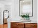 Hallway features wooden cabinet, art, and a glimpse into a living area with hardwood floors at 1140 Oak Ne St, St Petersburg, FL 33701