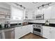 Charming kitchen with white cabinets, stainless steel appliances, and warm-toned tile floors at 1140 Oak Ne St, St Petersburg, FL 33701