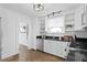 Bright kitchen with white cabinetry, black countertops, stainless steel appliances, and classic tile flooring at 1140 Oak Ne St, St Petersburg, FL 33701