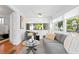 Comfortable living room featuring gray sofas, hardwood floors, and large windows for ample natural light at 1140 Oak Ne St, St Petersburg, FL 33701
