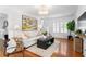 Cozy living room featuring hardwood floors, a modern sofa, and plenty of natural light at 1140 Oak Ne St, St Petersburg, FL 33701