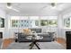 Bright living room featuring a gray sofa, hardwood floors, and an abundance of natural light at 1140 Oak Ne St, St Petersburg, FL 33701