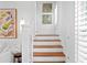 Bright staircase with hardwood treads, white risers and walls, with art and natural light at 1140 Oak Ne St, St Petersburg, FL 33701