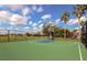 Outdoor basketball court offers recreation with a hoop, painted surface, and perimeter fencing on a sunny day at 11575 84Th Street E Cir # 104, Parrish, FL 34219