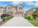 Charming two-story townhome featuring a concrete driveway, a two-car garage, and manicured landscaping at 11575 84Th Street E Cir # 104, Parrish, FL 34219
