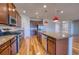 Modern kitchen with wood floors, granite countertops, stainless appliances and red pendant lights at 11924 Persian Ter, Bradenton, FL 34212