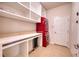 Laundry area with modern red washer/dryer, workspace, shelving, and tile flooring at 11924 Persian Ter, Bradenton, FL 34212