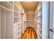 Spacious walk-in closet with custom shelving, drawers, and hardwood floors at 11924 Persian Ter, Bradenton, FL 34212