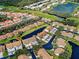 Stunning aerial view of a villa community with ponds, golf course, and lush greenery at 1211 Capri Isles Blvd # 26, Venice, FL 34292