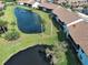 Aerial view of villas in a tranquil neighborhood with water features and mature trees at 1211 Capri Isles Blvd # 26, Venice, FL 34292