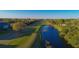 Picturesque aerial view overlooking a tranquil lake and lush green golf course in a vibrant community at 1211 Capri Isles Blvd # 26, Venice, FL 34292