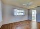 Well-lit bedroom with wood-look flooring features a ceiling fan and window with translucent curtains at 1211 Capri Isles Blvd # 26, Venice, FL 34292