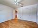 Clean bedroom with wood-look floors features a ceiling fan and convenient closet for storage at 1211 Capri Isles Blvd # 26, Venice, FL 34292