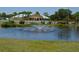 Scenic view of community building with a pond and fountain in a beautifully landscaped setting at 1211 Capri Isles Blvd # 26, Venice, FL 34292