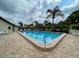 Well-maintained community pool area with palm trees and ample seating for residents at 1211 Capri Isles Blvd # 26, Venice, FL 34292