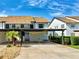 Two-story condominium with covered parking and a mature palm tree in the front yard at 1211 Capri Isles Blvd # 26, Venice, FL 34292