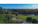 Scenic golf course view with lush green fairways, sand traps, and mature trees under a clear blue sky at 1211 Capri Isles Blvd # 26, Venice, FL 34292