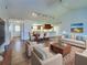 Spacious living room open to dining and kitchen, featuring vaulted ceilings and wood-look tile flooring at 1211 Capri Isles Blvd # 26, Venice, FL 34292