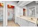 Bathroom with double sinks, decorative wallpaper, and bright vanity lighting at 1211 Spoonbill Landings Cir, Bradenton, FL 34209