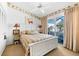 Cozy bedroom with decorative wallpaper, ceiling fan, and sliding glass doors to lanai at 1211 Spoonbill Landings Cir, Bradenton, FL 34209