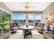 Inviting lanai featuring comfortable chairs, a ceiling fan, and picturesque waterfront views at 1211 Spoonbill Landings Cir, Bradenton, FL 34209