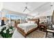 Spacious main bedroom with serene waterfront views, mirrored wall, and a ceiling fan at 1211 Spoonbill Landings Cir, Bradenton, FL 34209