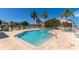 Gorgeous community pool with comfortable seating, surrounded by lush greenery and swaying palm trees at 1211 Spoonbill Landings Cir, Bradenton, FL 34209