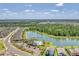 Aerial image of a community with a swimming pool and clubhouse situated next to a beautiful lake at 13013 Oak Hill Way, Parrish, FL 34219